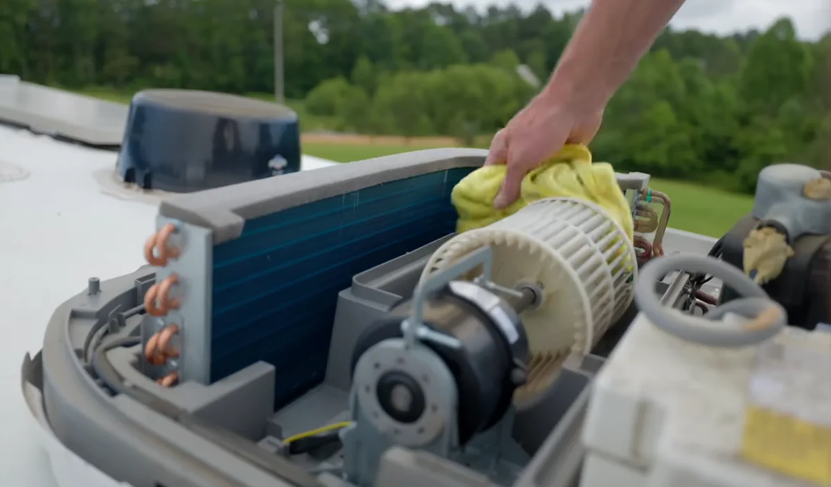 Marcus Reyes inspecting a Dometic Brisk Air rooftop AC unit at a Miami-Dade campground