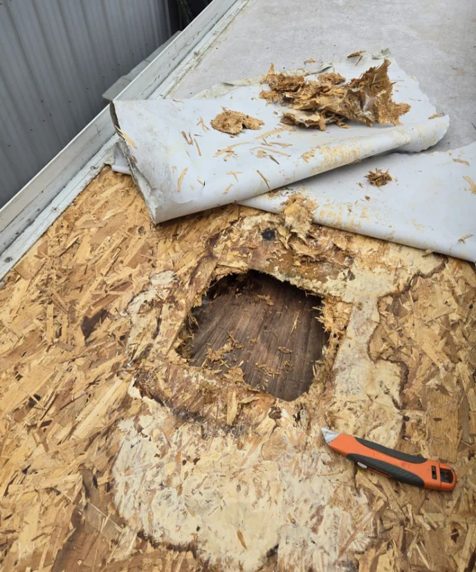 EPDM rubber roof with tear damage being patched at a Doral storage facility